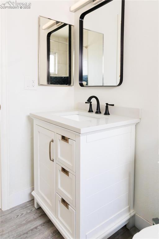 bathroom with wood finished floors and vanity