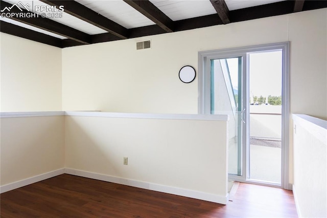 spare room featuring baseboards, visible vents, beam ceiling, and dark wood-type flooring