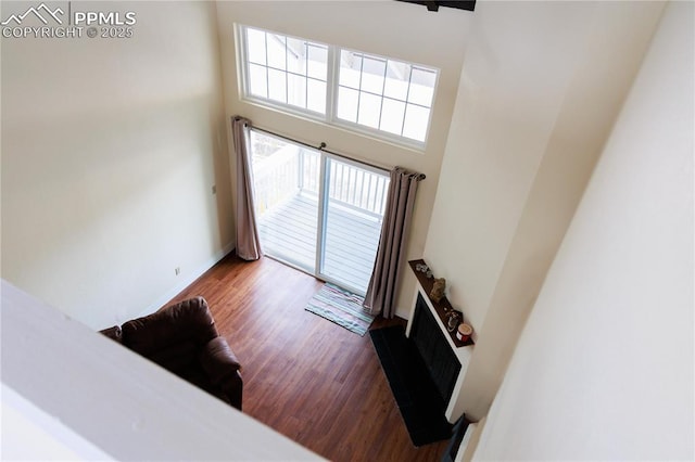 stairway featuring baseboards, wood finished floors, and a towering ceiling