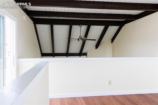 interior space featuring vaulted ceiling with beams, light wood-style floors, baseboards, and a ceiling fan