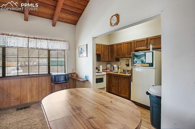 kitchen featuring beam ceiling, a sink, white appliances, visible vents, and wood ceiling
