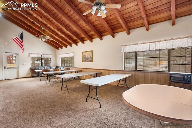 interior space with wood ceiling, carpet floors, a ceiling fan, and beam ceiling