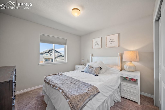 bedroom with baseboards and dark colored carpet