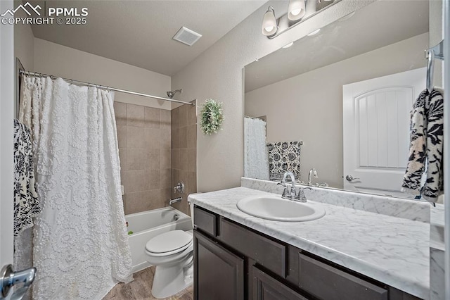 bathroom featuring visible vents, vanity, wood finished floors, shower / bath combination with curtain, and toilet