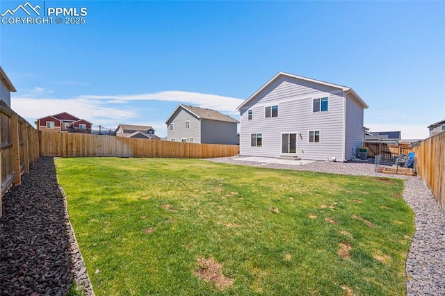 rear view of property featuring a yard, a fenced backyard, and a patio area