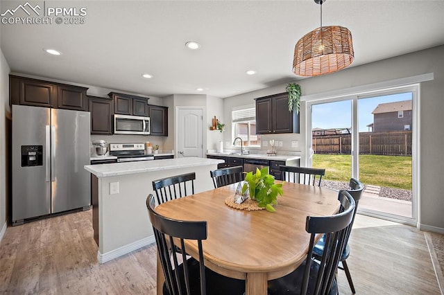 dining space featuring recessed lighting, light wood finished floors, and baseboards