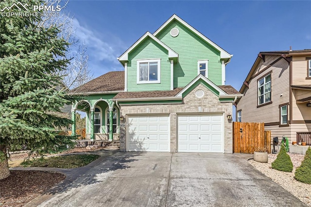 view of front of home featuring fence, driveway, a shingled roof, and a garage