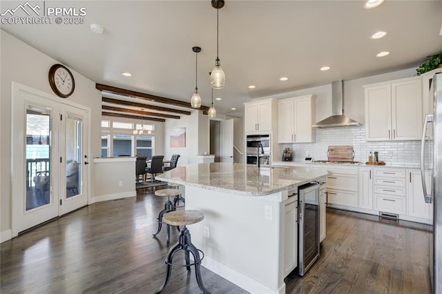 kitchen with wall chimney range hood, dark wood-style flooring, white cabinetry, and wine cooler