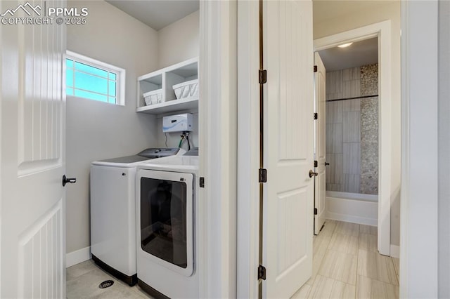 washroom with washing machine and dryer, laundry area, and baseboards