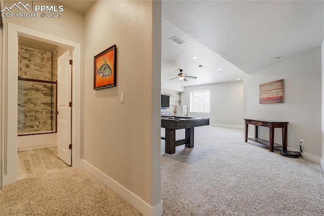 hall with carpet floors, baseboards, and visible vents