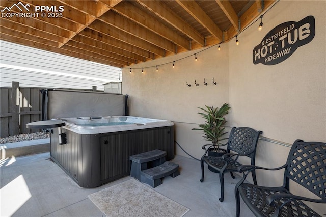 view of patio / terrace featuring fence and a hot tub