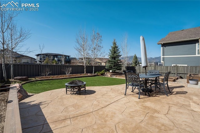 view of patio featuring an outdoor fire pit, outdoor dining space, and a fenced backyard
