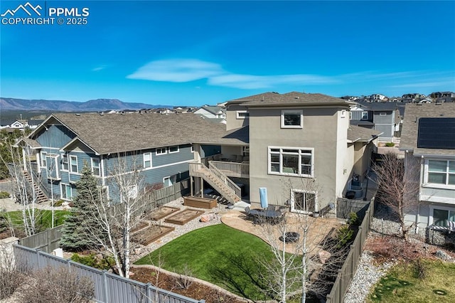 rear view of property with stucco siding, a mountain view, stairway, a patio area, and a fenced backyard