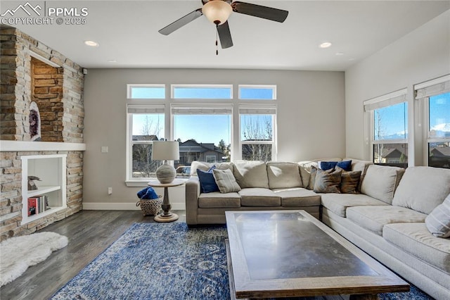 living room featuring ceiling fan, plenty of natural light, wood finished floors, and baseboards
