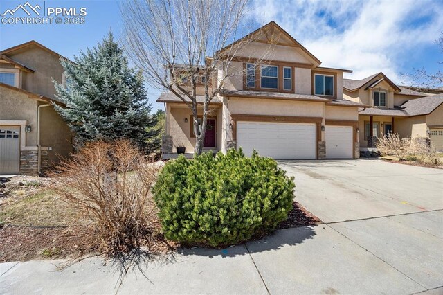 4454 College Park Ct, Colorado Springs, CO 80918 - view of front of property with stucco siding, an attached garage, stone siding, and concrete driveway