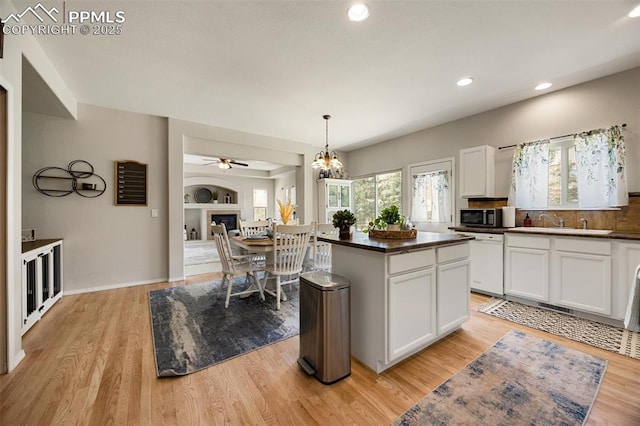 4454 College Park Ct, Colorado Springs, CO 80918 - kitchen with stainless steel microwave, dark countertops, light wood-style floors, white cabinets, and white dishwasher
