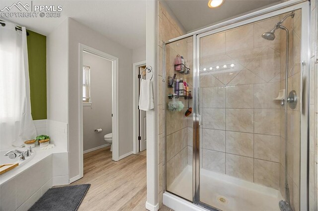4454 College Park Ct, Colorado Springs, CO 80918 - bathroom featuring a stall shower, wood finished floors, toilet, and a bath
