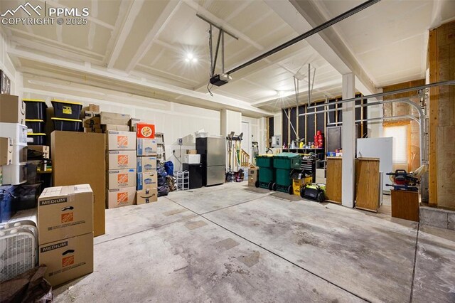 4454 College Park Ct, Colorado Springs, CO 80918 - garage featuring a garage door opener and freestanding refrigerator