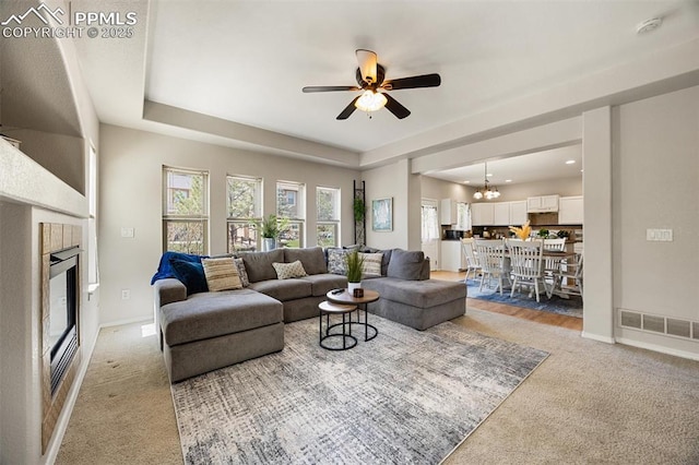 4454 College Park Ct, Colorado Springs, CO 80918 - living area with visible vents, light carpet, a glass covered fireplace, and plenty of natural light