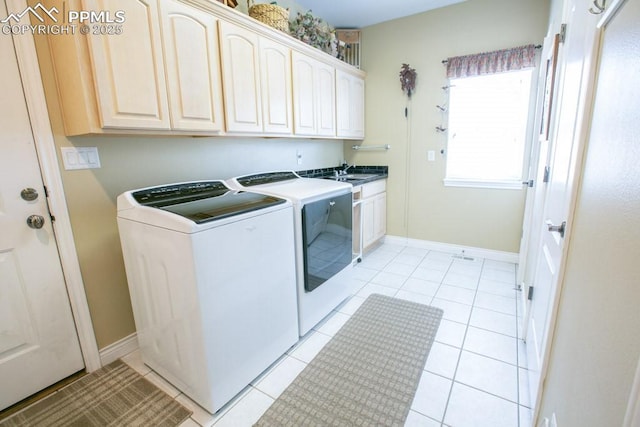 17035 Herring Rd, Colorado Springs, CO 80908 - laundry area featuring baseboards, light tile patterned floors, washing machine and clothes dryer, cabinet space, and a sink