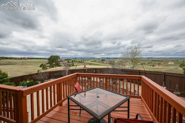 17035 Herring Rd, Colorado Springs, CO 80908 - wooden deck featuring a fenced backyard, outdoor dining space, and a rural view