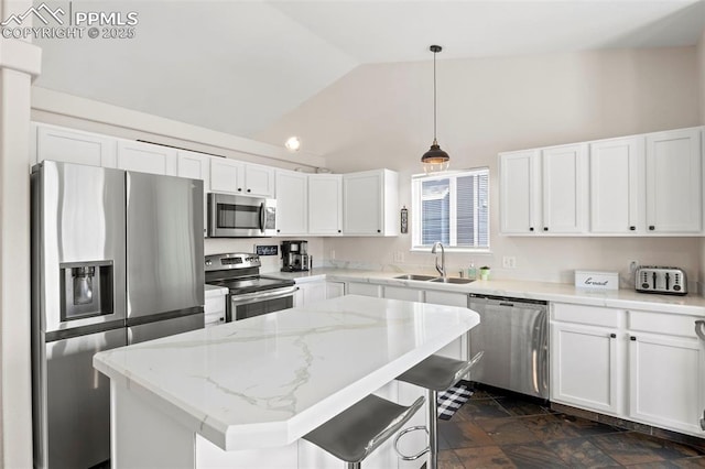 kitchen featuring light stone counters, hanging light fixtures, a sink, stainless steel appliances, and white cabinetry