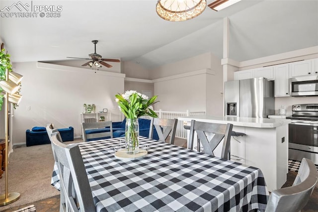 dining room with dark carpet, lofted ceiling, and a ceiling fan