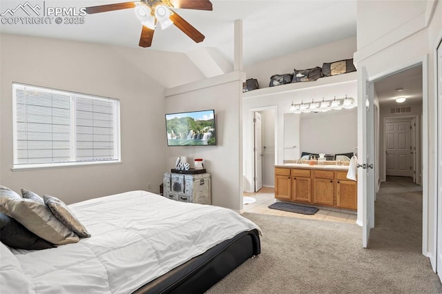 bedroom with lofted ceiling, visible vents, ensuite bath, light colored carpet, and ceiling fan