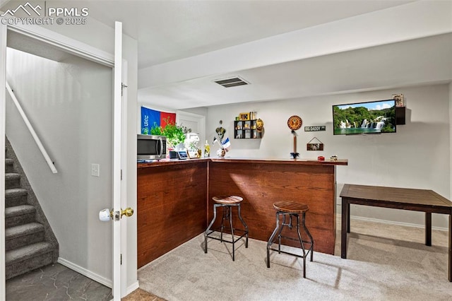 bar featuring a dry bar, stainless steel microwave, visible vents, baseboards, and stairway