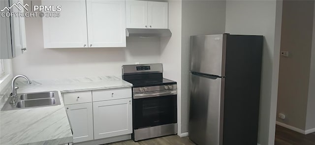 131 Hayes Dr, Colorado Springs, CO 80911 - kitchen with under cabinet range hood, white cabinets, appliances with stainless steel finishes, and a sink