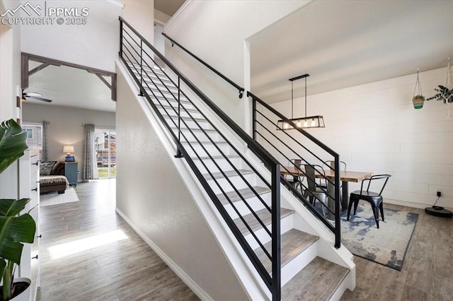 13424 Stone Valley Dr, Peyton, CO 80831 - stairway with baseboards, wood finished floors, and ceiling fan with notable chandelier