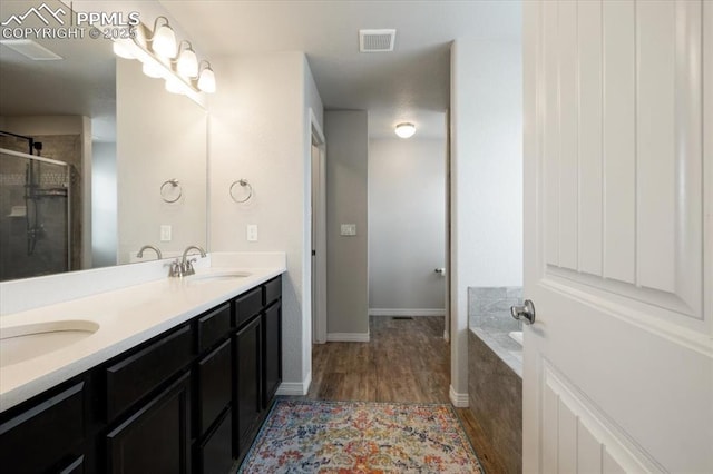 13424 Stone Valley Dr, Peyton, CO 80831 - full bathroom featuring a shower stall, wood finished floors, a sink, and visible vents
