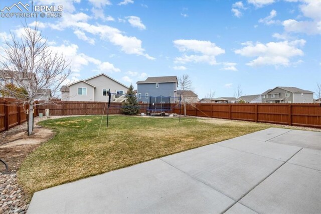 13424 Stone Valley Dr, Peyton, CO 80831 - view of yard with a fenced backyard, a trampoline, a patio, and a residential view