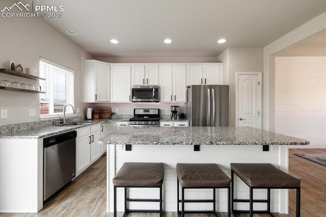 13424 Stone Valley Dr, Peyton, CO 80831 - kitchen with stainless steel appliances, white cabinets, a sink, and light stone counters