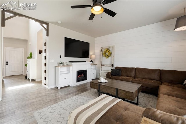 13424 Stone Valley Dr, Peyton, CO 80831 - living area with baseboards, a ceiling fan, wood finished floors, and a lit fireplace