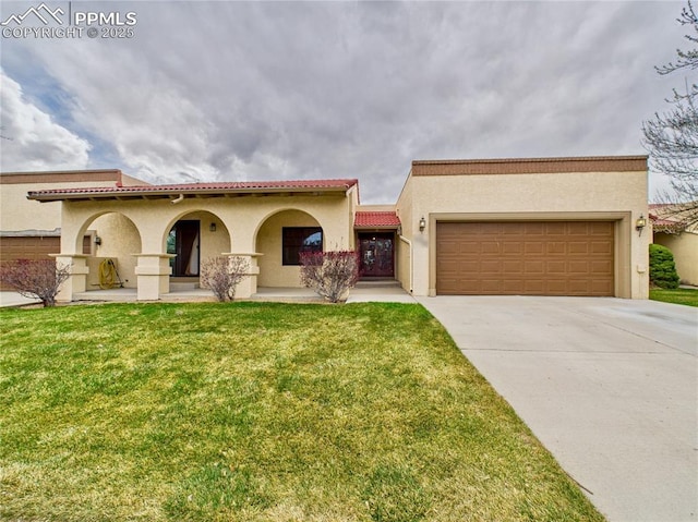 mediterranean / spanish home featuring a front lawn, driveway, stucco siding, and an attached garage