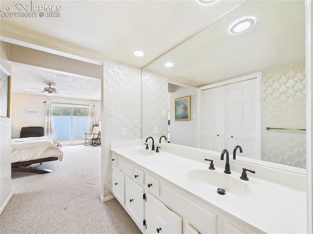 ensuite bathroom with a ceiling fan, double vanity, a sink, and ensuite bathroom