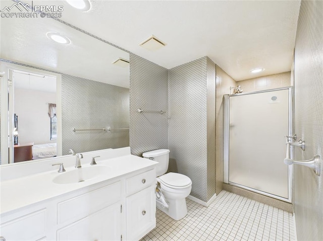 full bathroom featuring a shower stall, toilet, vanity, ensuite bath, and tile patterned flooring