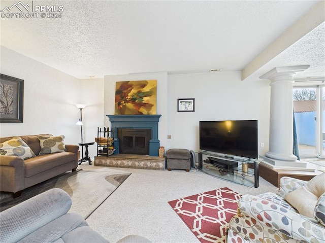 living area featuring ornate columns, carpet floors, a textured ceiling, and visible vents