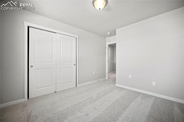 unfurnished bedroom featuring a closet, carpet floors, visible vents, and baseboards