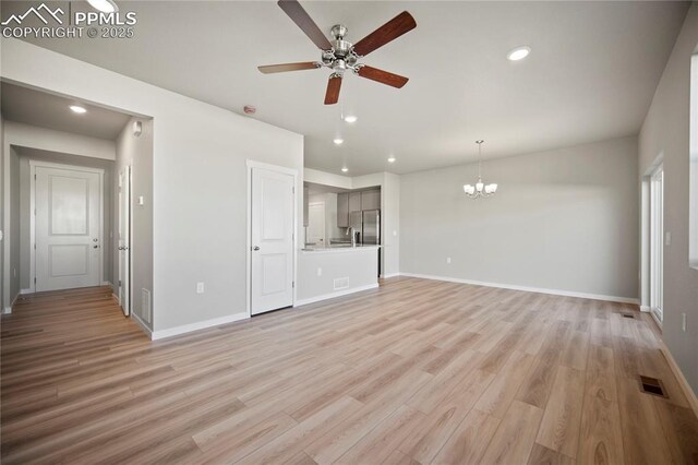 unfurnished living room featuring light wood finished floors, baseboards, ceiling fan with notable chandelier, visible vents, and recessed lighting