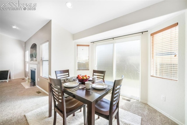 3841 Sonoran Dr, Colorado Springs, CO 80922 - dining area featuring a fireplace with flush hearth, carpet flooring, baseboards, and visible vents