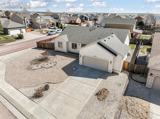 3841 Sonoran Dr, Colorado Springs, CO 80922 - exterior space with a garage, fence, concrete driveway, stucco siding, and a residential view
