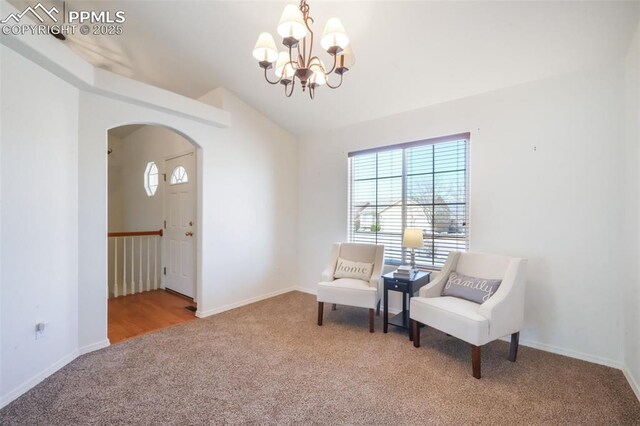 3841 Sonoran Dr, Colorado Springs, CO 80922 - sitting room featuring arched walkways, an inviting chandelier, a wealth of natural light, and carpet floors