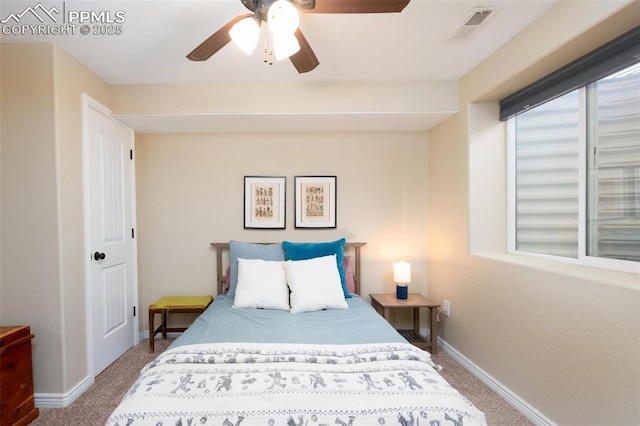 carpeted bedroom featuring baseboards, a ceiling fan, multiple windows, and visible vents