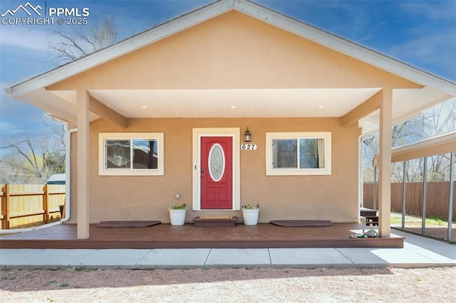 view of front of home with stucco siding and fence