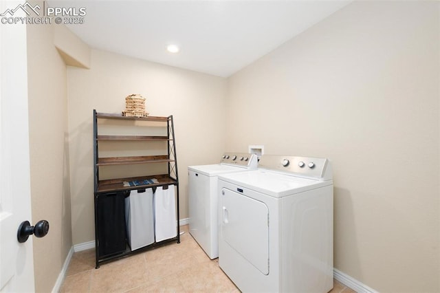 clothes washing area featuring baseboards, washer and clothes dryer, and laundry area