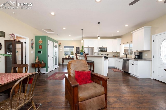 living area featuring dark wood-type flooring, a healthy amount of sunlight, and recessed lighting