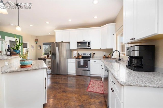 kitchen featuring stainless steel appliances, a sink, white cabinetry, and dark wood-style flooring