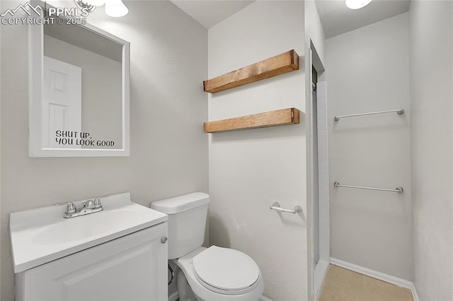 bathroom featuring tile patterned floors, toilet, vanity, and walk in shower